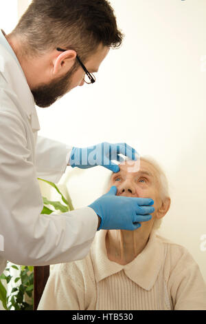 Le médecin examine les yeux, la très vieille femme Le médecin gériatre au cours de l'essai. Banque D'Images