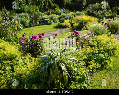 Chenies Manor jardin en contrebas, dans le Buckinghamshire. Soleil du soir les couleurs améliorées de feuillage, et l'alchémille dahlias rose foncé ajouter à leur beauté. Banque D'Images