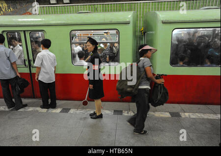 09.08.2012, Pyongyang, Corée du Nord - un superviseur de plate-forme est à côté d'un métro en attente à la gare de Pyongyang. Banque D'Images