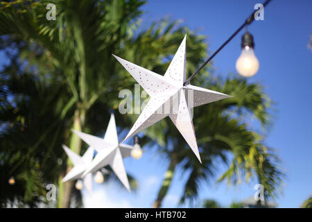 White Star decorations hanging sur corde noir dans le ciel bleu Banque D'Images