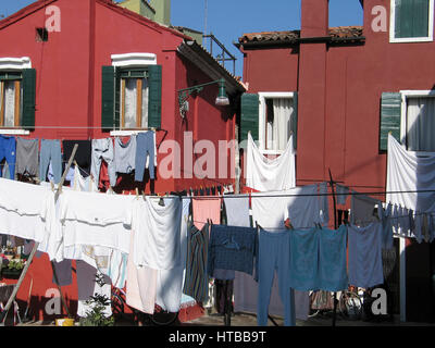 Linge coloré séchant au soleil dans les rues animées de Burano, Venise . Italie Banque D'Images