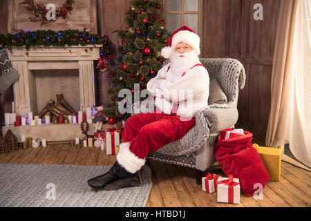 Smiling Santa Claus sitting in armchair Banque D'Images