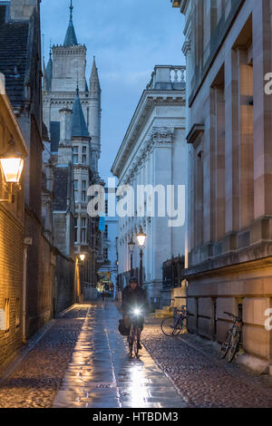 Un étudiant sur cycliste Sénat Chambre Passage au crépuscule, Cambridge, England, UK Banque D'Images