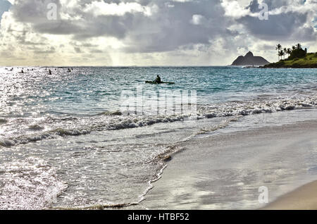 Kailua, Hawaii, USA - 30 juillet 2016 : Les gens de paddle-pirogues sur la plage au lever du soleil Banque D'Images