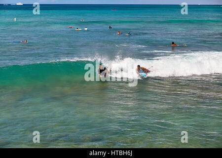 La plage de Waikiki, Hawaii, USA -- 2 Août 2016 : Unidentified boogie board surfeurs attraper une vague de Waikiki Beach Florida Banque D'Images