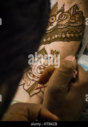 Une Henna Mehndi / artiste travaillant sur un bras de la mariée henné lors d'une partie. La figure de l'éléphant Ganesha, est l'un des plus connu et le plus vénéré dieti Banque D'Images