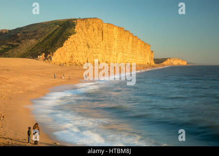 Frère et soeur à regarder les vagues sur la plage ci-dessous East Cliff, West Bay, sur la côte jurassique, Dorset, England, UK Frère et soeur à regarder les vagues sur la plage ci-dessous East Cliff, West Bay, sur la côte jurassique, Dorset, England, UK