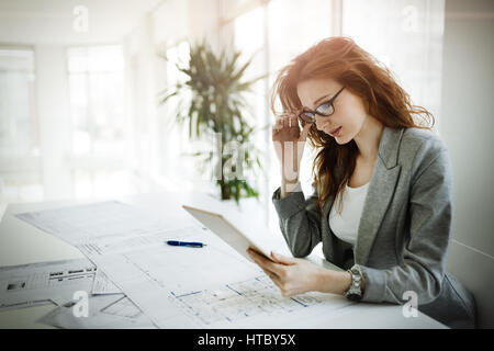 Belle femme architecte travaillant sur plan en bureau de l'entreprise Banque D'Images