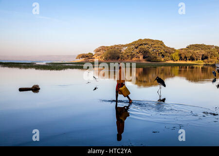 Un adolescent recueille l'eau du lac dans des conteneurs, le lac Awassa, Ethiopie Banque D'Images