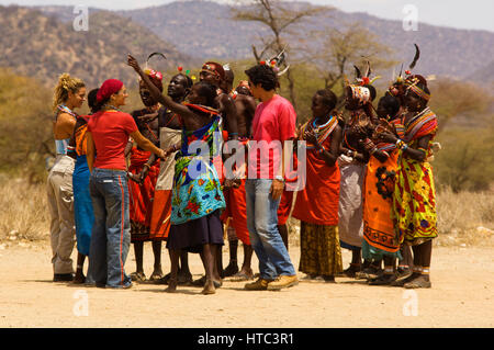 Les guerriers Samburu danse avec les touristes dans un près de manyatta Archers Post, Samburu National Park, Kenya Banque D'Images