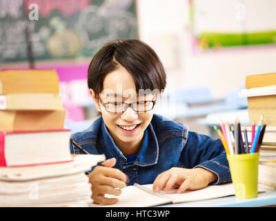 Happy asian elementary school boy studying in classroom souriant. Banque D'Images