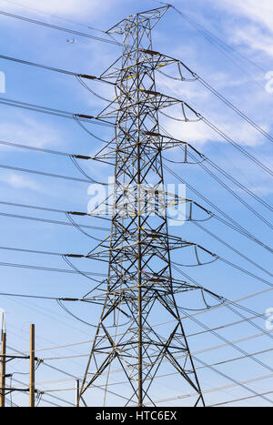 Un des pylônes d'électricité à haute tension contre le ciel bleu et rayons de soleil Banque D'Images