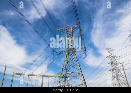 Un des pylônes d'électricité à haute tension contre le ciel bleu et rayons de soleil Banque D'Images