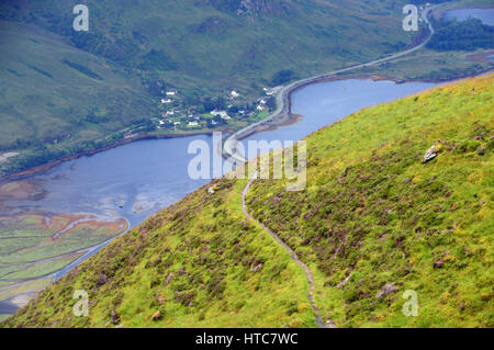 À la recherche jusqu'à la chaussée sur Loch Duich du sentier de la montagne écossaise Corbett Sgurr une Airgid dans les Highlands écossais. Banque D'Images