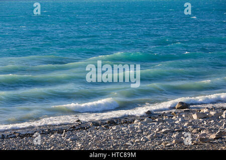 Murchison, Canterbury, Nouvelle-Zélande. Vagues se brisant sur le rivage rocheux du lac Pukaki. Banque D'Images