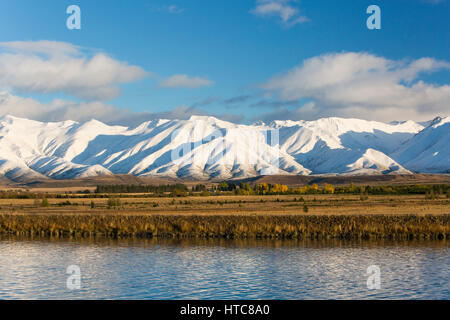 Murchison, Canterbury, Nouvelle-Zélande. La gamme Ben Ohau enveloppé dans la neige de l'automne, début de matinée, le Canal Pukaki en premier plan. Banque D'Images