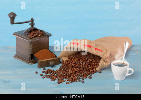 Rectifieuse de café et grains de café dans un sac. Fond bleu. Banque D'Images