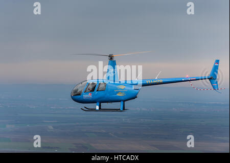 Hélicoptère Robinson R44 lumière exploités par des hélicoptères des Balkans en vol, photographié d'un autre hélicoptère Banque D'Images