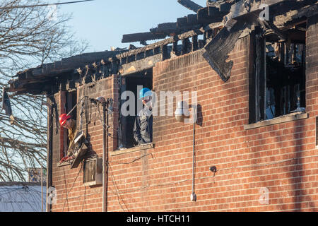 Detroit, Michigan - Police et d'incendie Incendie criminel enquêteurs sur les lieux d'un appartement en feu qui a tué cinq personnes. Le sapin-set délibérément Banque D'Images