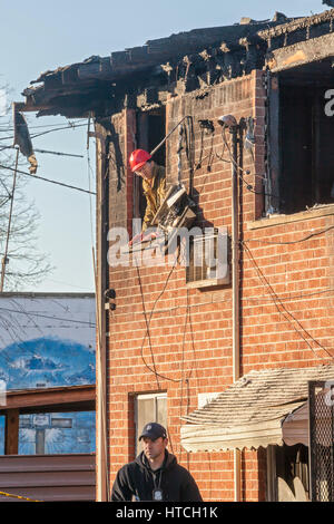 Detroit, Michigan - Police et d'incendie Incendie criminel enquêteurs sur les lieux d'un appartement en feu qui a tué cinq personnes. Le sapin-set délibérément Banque D'Images