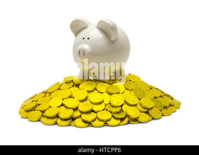 Tirelire sur le dessus de la pile de pièces d'or isolé sur blanc. Banque D'Images