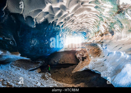 Un homme se tient à l'intérieur d'une immense caverne de glace dans le Glacier Canwell dans la chaîne de l'Alaska en hiver, l'intérieur de l'Alaska, USA Banque D'Images