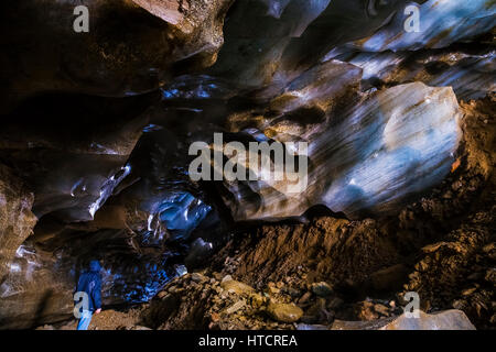 Un homme se tient à l'intérieur d'une grotte de glace massive au sein de Castner Glacier dans la chaîne de l'Alaska à l'été, l'intérieur de l'Alaska, USA Banque D'Images