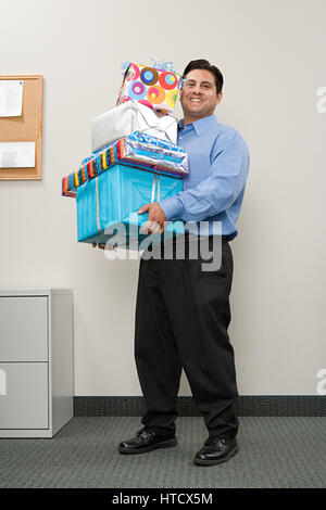 Man carrying pile of presents Banque D'Images