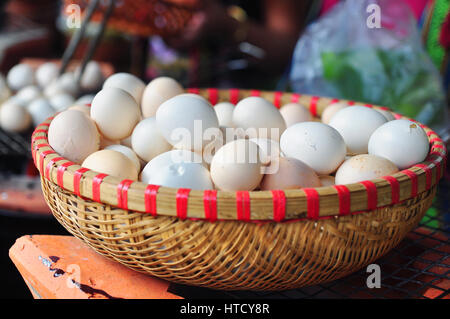 Blanc de poulet oeufs dans le panier de bambou Banque D'Images