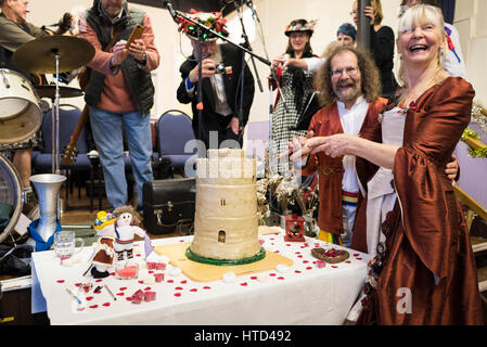 La danse morris nouveau couple couper le gâteau à leur réception de mariage (gâteau inspiré par le grand donjon du château de Pembroke au Pays de Galles). Banque D'Images