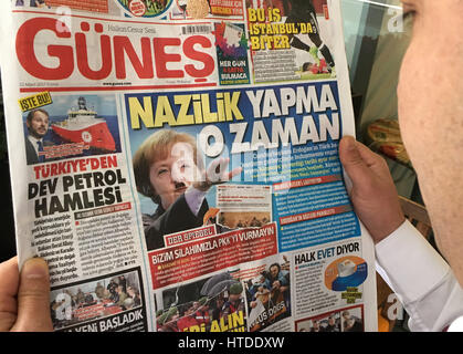 Istanbul, Turquie. 10 Mar, 2017. Un homme lisant un journal 'Günes' avec un montage photographique montrant la Chancelière allemande, Angela Merkel, avec une moustache d'Hitler donnant un salut nazi vu à Istanbul, Turquie, 10 mars 2017. Photo : Linda Dire/dpa/Alamy Live News Banque D'Images