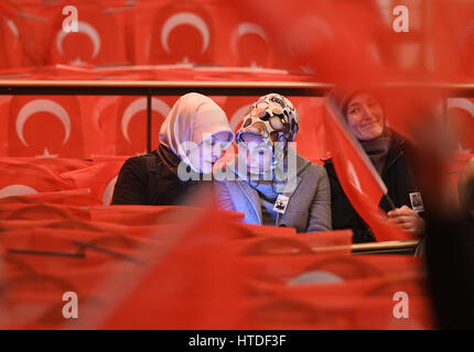 Cologne, Allemagne. 10 mars 2017. Les participants regardent sports ministre turc Akif Cagatay Kilic sur smart phone pendant un événement intitulé "Helden unter uns. 15. Juli' le 10 mars 2017 à Cologne, Allemagne. Le titre de l'événement fait référence au 15 juillet 2016 qui était la date de la tentative de coup d'État en Turquie. Photo : Henning Kaiser/dpa/Alamy Live News Banque D'Images