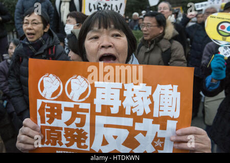 Tokyo, Tokyo, Japon. Mar 11, 2017. Un manifestant anti-nucléaire est titulaire d'une plaque à l'extérieur du bâtiment de la Diète nationale lors d'une manifestation tenue par la Coalition métropolitaine contre Nukes à Tokyo. La protestation vient au cours du sixième anniversaire du grand séisme de l'Est du Japon et le tsunami qui ont conduit à l'éclatement de la crise nucléaire de Fukushima. Credit : Alessandro Di Ciommo/ZUMA/Alamy Fil Live News Banque D'Images