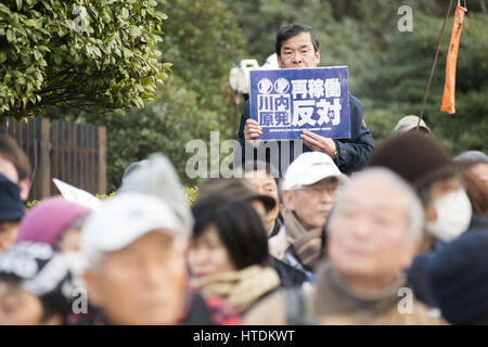 Tokyo, Tokyo, Japon. Mar 11, 2017. Un manifestant anti-nucléaire est titulaire d'une plaque à l'extérieur du bâtiment de la Diète nationale lors d'une manifestation tenue par la Coalition métropolitaine contre Nukes à Tokyo. La protestation vient au cours du sixième anniversaire du grand séisme de l'Est du Japon et le tsunami qui ont conduit à l'éclatement de la crise nucléaire de Fukushima. Credit : Alessandro Di Ciommo/ZUMA/Alamy Fil Live News Banque D'Images