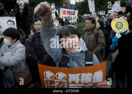 Tokyo, Tokyo, Japon. Mar 11, 2017. Un manifestant anti-nucléaire est titulaire d'une plaque à l'extérieur du bâtiment de la Diète nationale lors d'une manifestation tenue par la Coalition métropolitaine contre Nukes à Tokyo. La protestation vient au cours du sixième anniversaire du grand séisme de l'Est du Japon et le tsunami qui ont conduit à l'éclatement de la crise nucléaire de Fukushima. Credit : Alessandro Di Ciommo/ZUMA/Alamy Fil Live News Banque D'Images