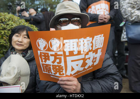 Tokyo, Tokyo, Japon. Mar 11, 2017. Un manifestant anti-nucléaire est titulaire d'une plaque à l'extérieur du bâtiment de la Diète nationale lors d'une manifestation tenue par la Coalition métropolitaine contre Nukes à Tokyo. La protestation vient au cours du sixième anniversaire du grand séisme de l'Est du Japon et le tsunami qui ont conduit à l'éclatement de la crise nucléaire de Fukushima. Credit : Alessandro Di Ciommo/ZUMA/Alamy Fil Live News Banque D'Images