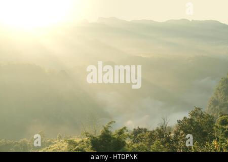 Le lever du soleil sur le paysage de montagne avec de beaux rayons de soleil et de faible altitude des nuages blancs. Banque D'Images