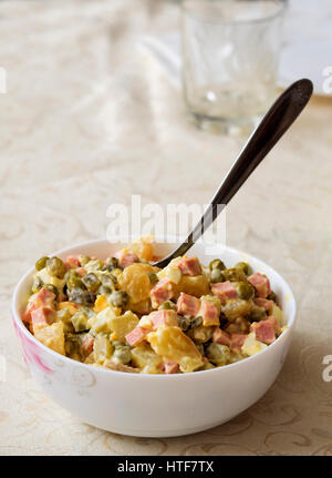 Dans un bol à salade combailloux fait maison sur la table. Olivier salade est un plat de salade traditionnelle dans la cuisine russe, qui est aussi très populaire dans de nombreux autres pays européens Banque D'Images