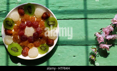 Confiture pour vietnamiens colorés Vietnam têt sur fond vert, de l'Asie du nouvel an lunaire, traditionnelle de fruits en conserves, kiwi, noix de coco, damson jam Banque D'Images