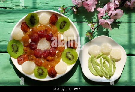 Confiture pour vietnamiens colorés Vietnam têt sur fond vert, de l'Asie du nouvel an lunaire, traditionnelle de fruits en conserves, kiwi, noix de coco, damson jam Banque D'Images