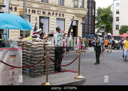 Les touristes ayant leurs photographies prises à Checkpoint Charlie, Berlin, Allemagne Banque D'Images