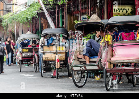 Location de pousse-pousse, également connu sous le nom de becaks, garée le long de la rue Malioboro à Yogyakarta - Java, Indonésie Banque D'Images