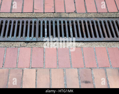 Grille de vidange en acier sur la tuile chemin dans la grande université. Banque D'Images