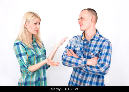 Jeune homme et femme se disputent en studio sur un fond blanc. Banque D'Images