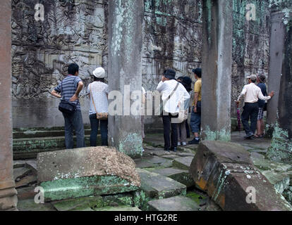 Scène de bataille bas-reliefs et les touristes à Angkor Thom temple. Temples d'Angkor, au Cambodge, en Asie Banque D'Images