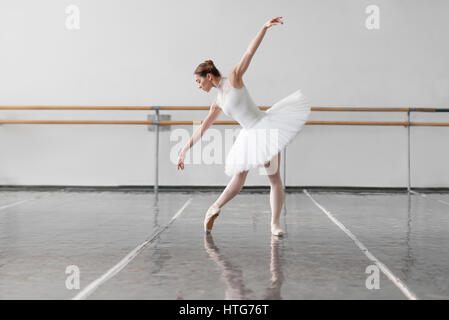 Ballerine belle répétition en classe de ballet, barre et mur blanc sur fond Banque D'Images