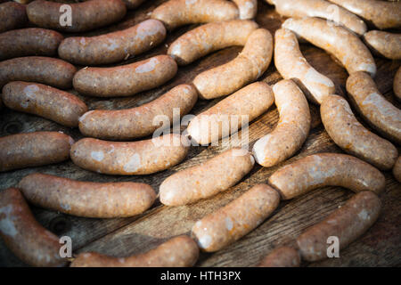 Des saucisses fraîches sur la table en bois Banque D'Images