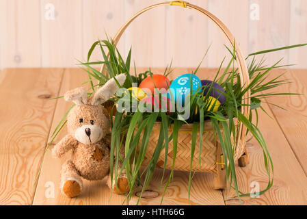 Lapin de Pâques et le panier avec les oeufs de Pâques peints sur des planches Banque D'Images