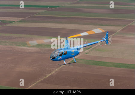 Hélicoptère Robinson R44 lumière exploités par des hélicoptères des Balkans en vol, photographié d'un autre hélicoptère Banque D'Images