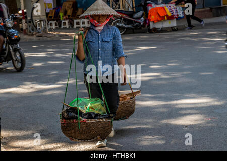 Les fournisseurs de téléphonie mobile à l'œuvre sur des cycles et à pied dans les rues de la capitale de Hanoi, Vietnam Banque D'Images